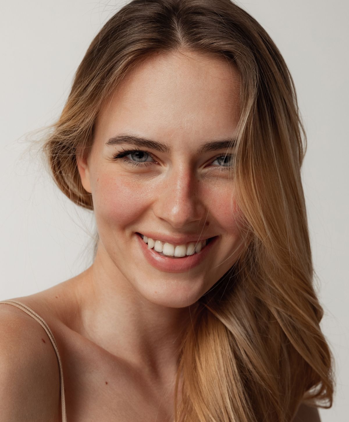 Smiling woman with long, wavy blonde hair.