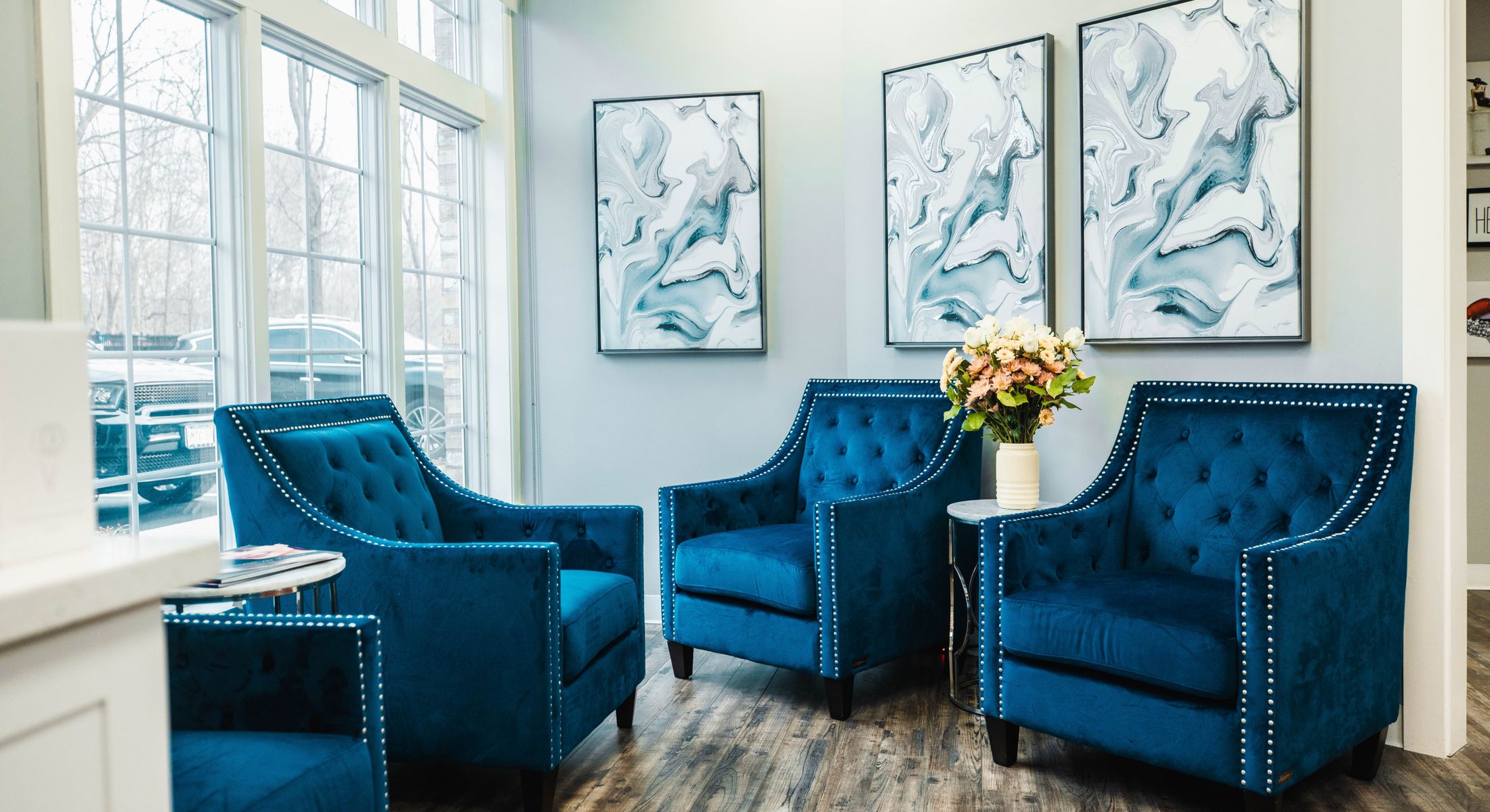 Cozy seating area with blue chairs and artwork.